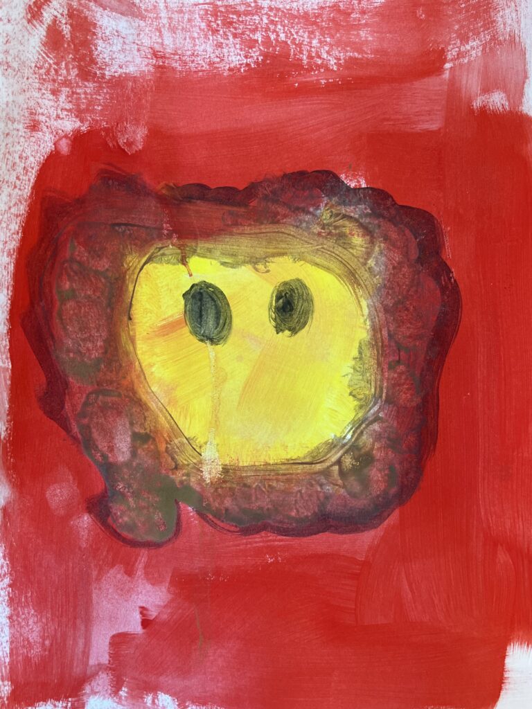 en gul huvudform med svarta ögon på röd bakgrund